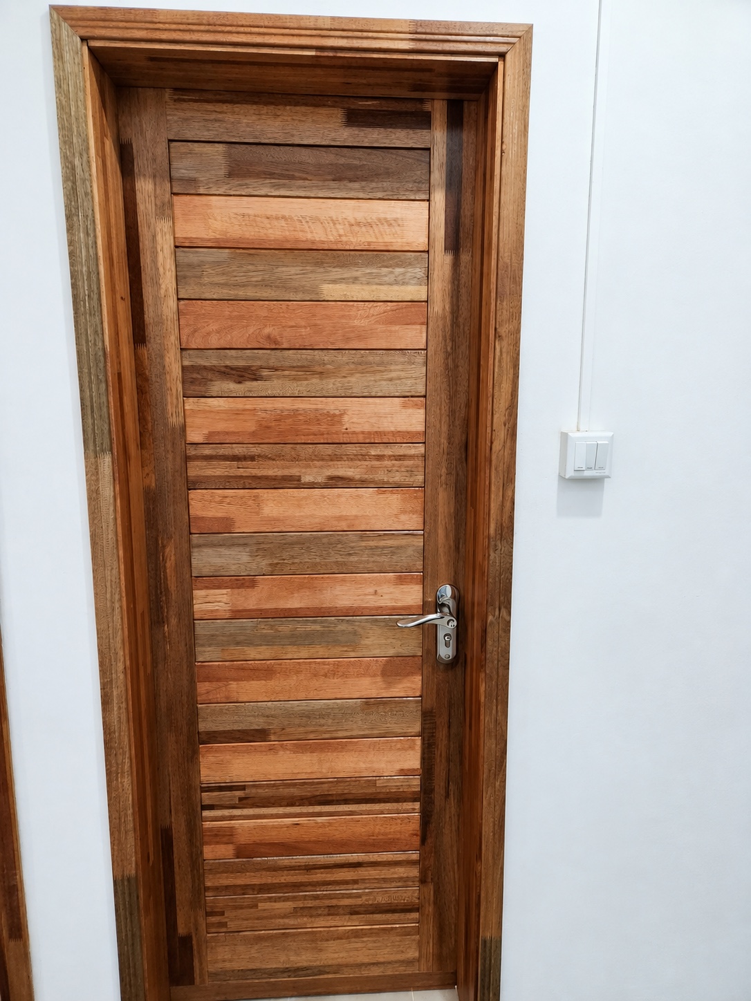 Installed timber door with horizontal panels and silver handle