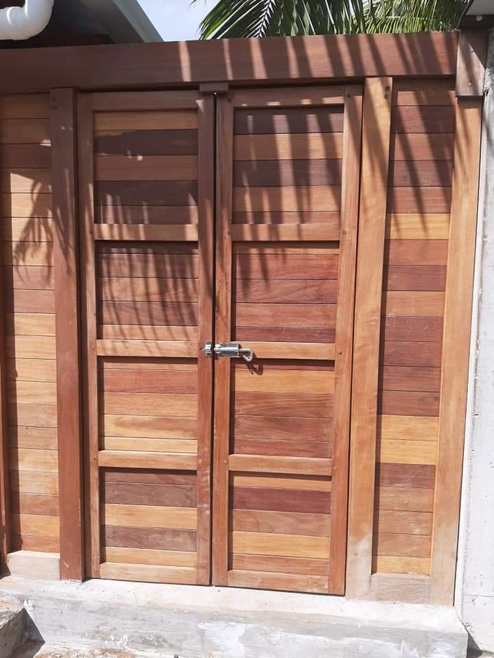 Double exterior timber gate with horizontal wood panels and a metal latch