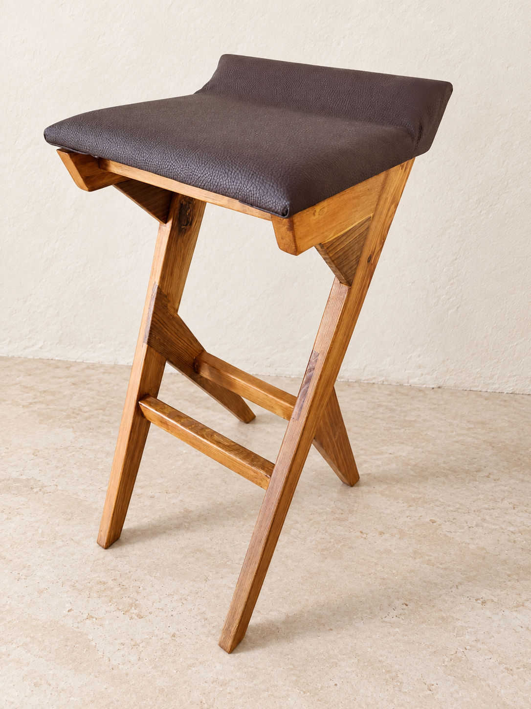 Wooden bar stool with a sculpted dark seat and angled legs